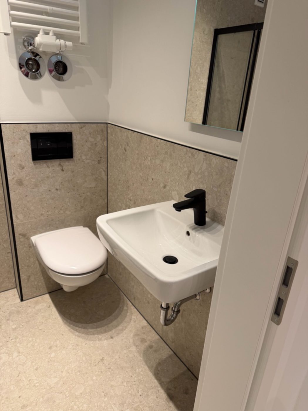 Badezimmer kurz vor Fertigstellung mit montiertem WC und Waschbecken