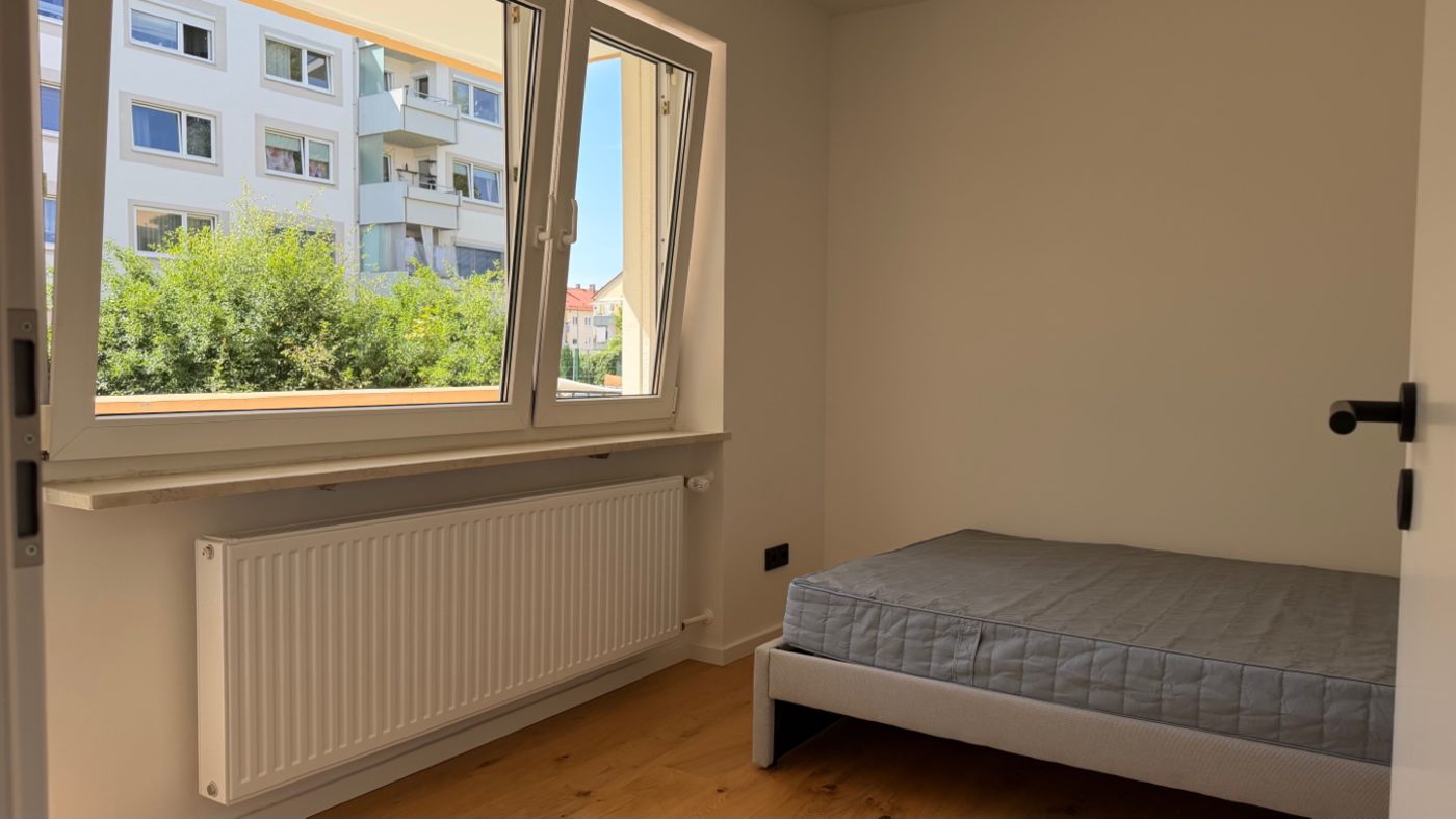 Fast fertiges Zimmer mit Bett und Heizkörper, Fenster mit Ausblick