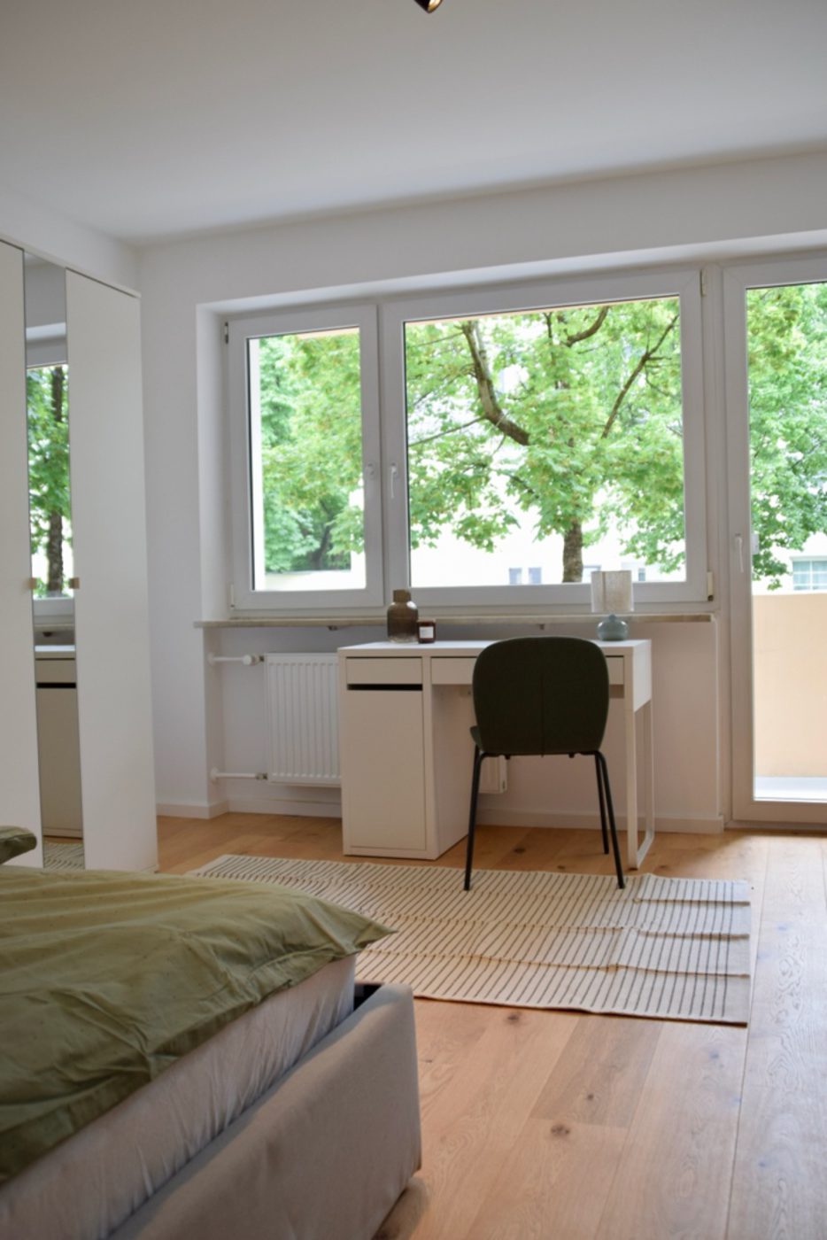 Fertiges Schlafzimmer mit Bett, Schreibtisch und Fenster