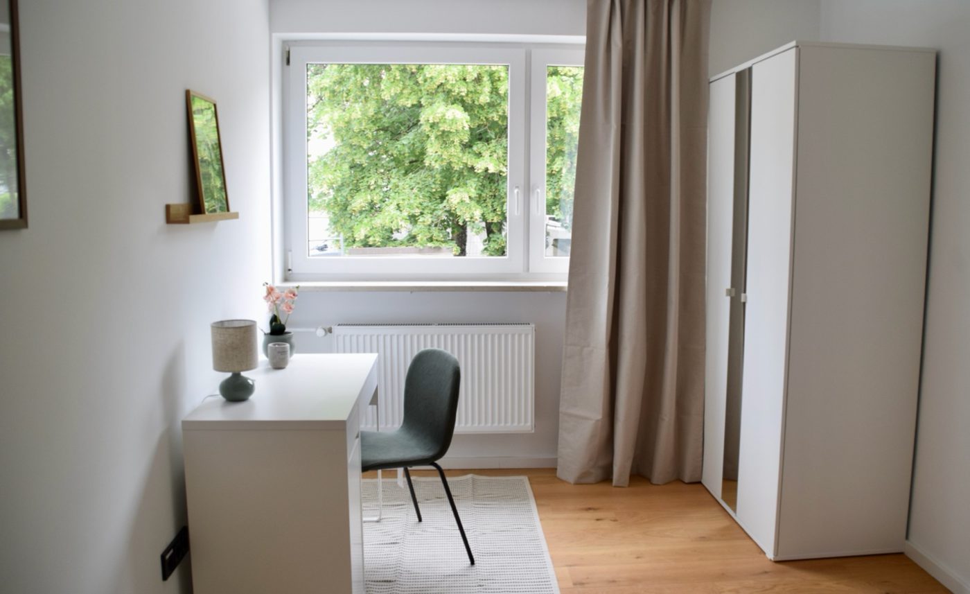 Fertiger heller Wohnraum mit hochwertigem Boden, Schreibtisch und Fenster