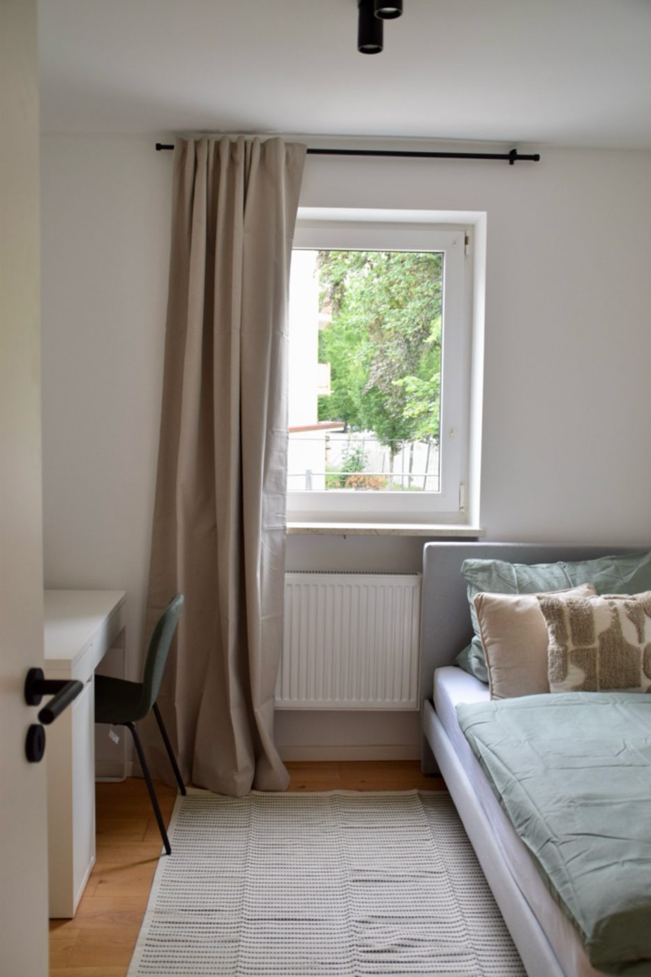 Fertiger Wohn-/Schlafbereich mit Bett, Vorhang und Arbeitsplatz